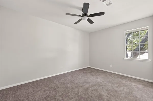 an empty room with closet and ceiling fan