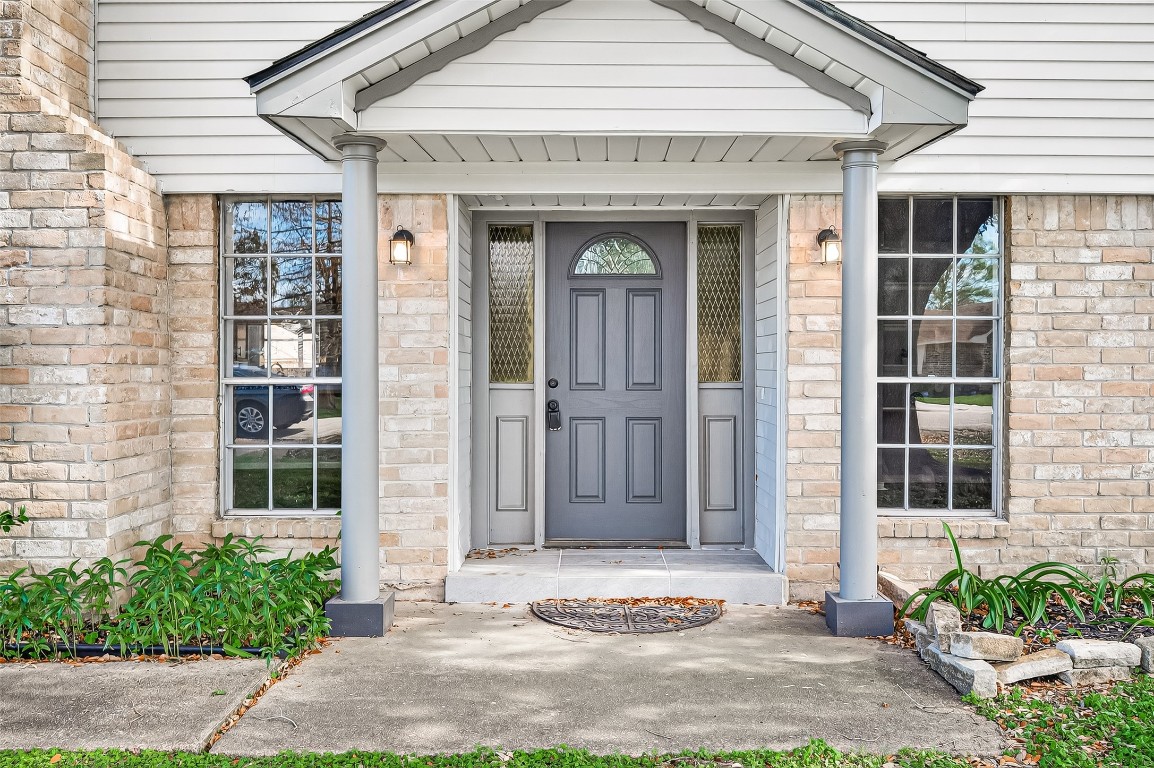 21710 Rotherham Drive Spring, TX 77388 - Photo 4 of 49 Covered front entry with brick façade, columns, and a front door with sidelights