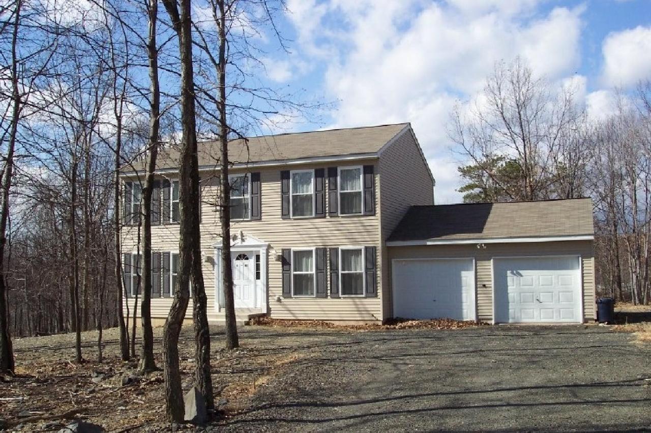 83 Snowflake Court Bushkill, PA 18324 - Photo 1 of 6 a front view of a house with a garden
