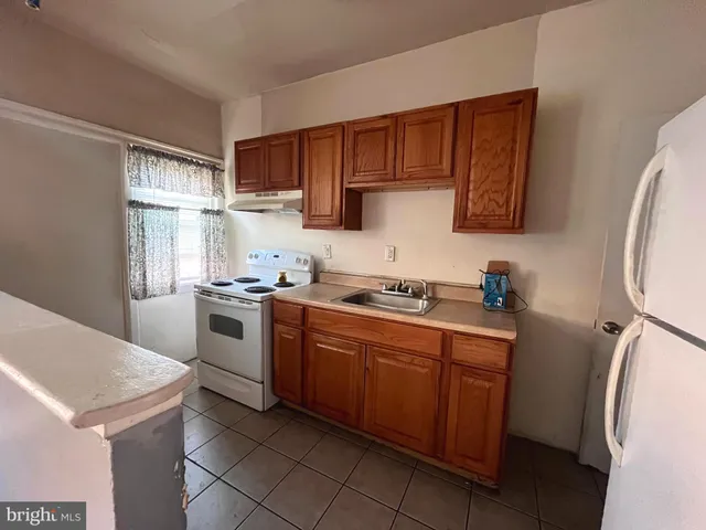 a kitchen with a stove sink and a refrigerator