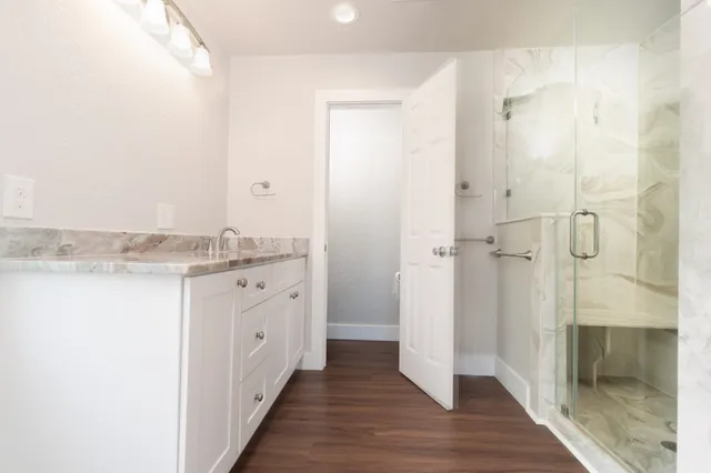 a bathroom with a granite countertop sink and a mirror