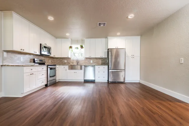a kitchen with stainless steel appliances a refrigerator sink and cabinets