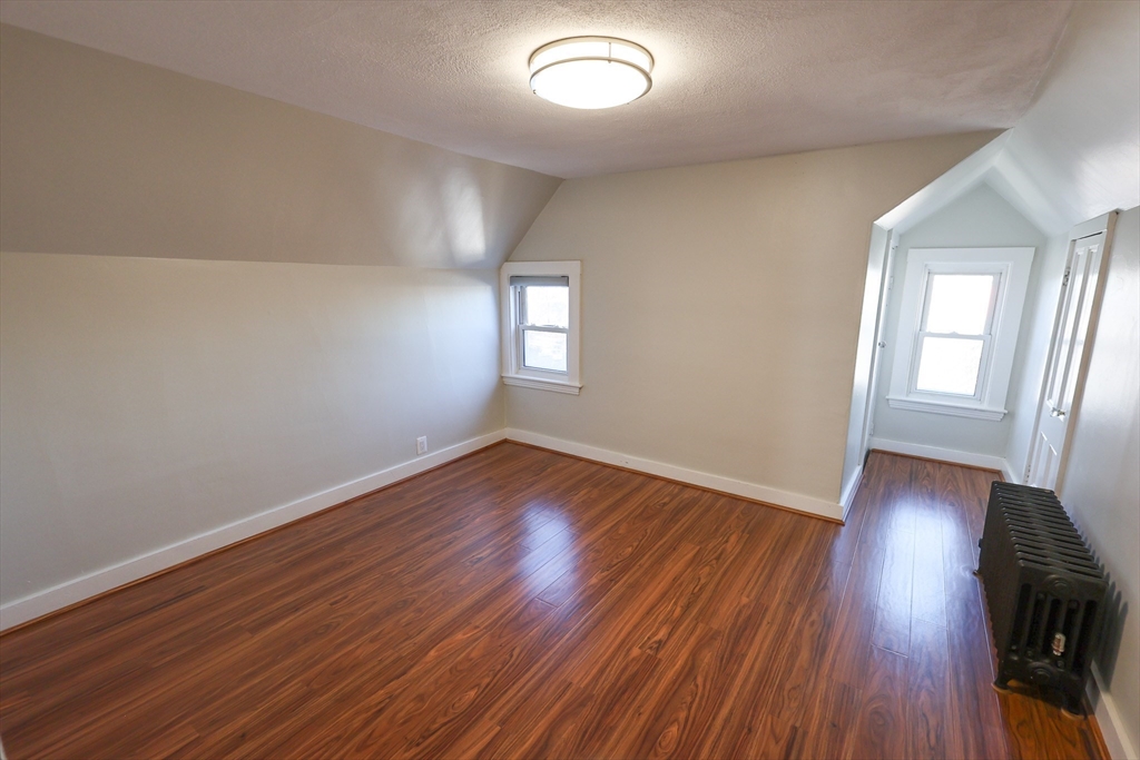 369 Savin Hill Avenue, Unit 3 Boston, MA 02125 - Photo 10 of 16 an empty room with wooden floor and windows