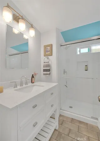 a bathroom with a shower sink vanity and mirror