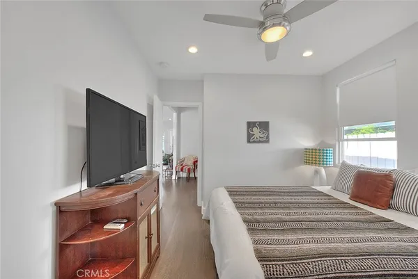 a bedroom with a bed and a flat tv screen on dresser
