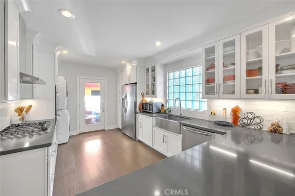 a kitchen with stainless steel appliances granite countertop a sink stove and cabinets