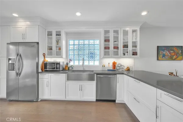 a kitchen with granite countertop a sink stainless steel appliances and cabinets