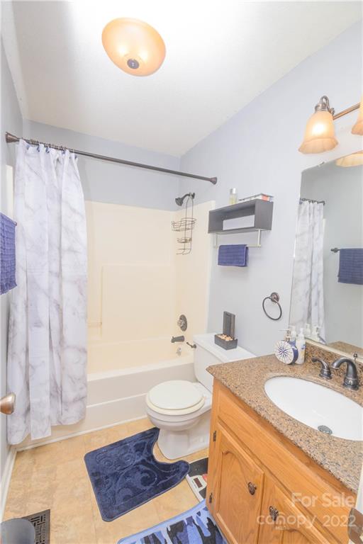 696 Forest Road Rock Hill, SC 29730 - Photo 5 of 15 a bathroom with a granite countertop sink toilet a mirror and shower curtain