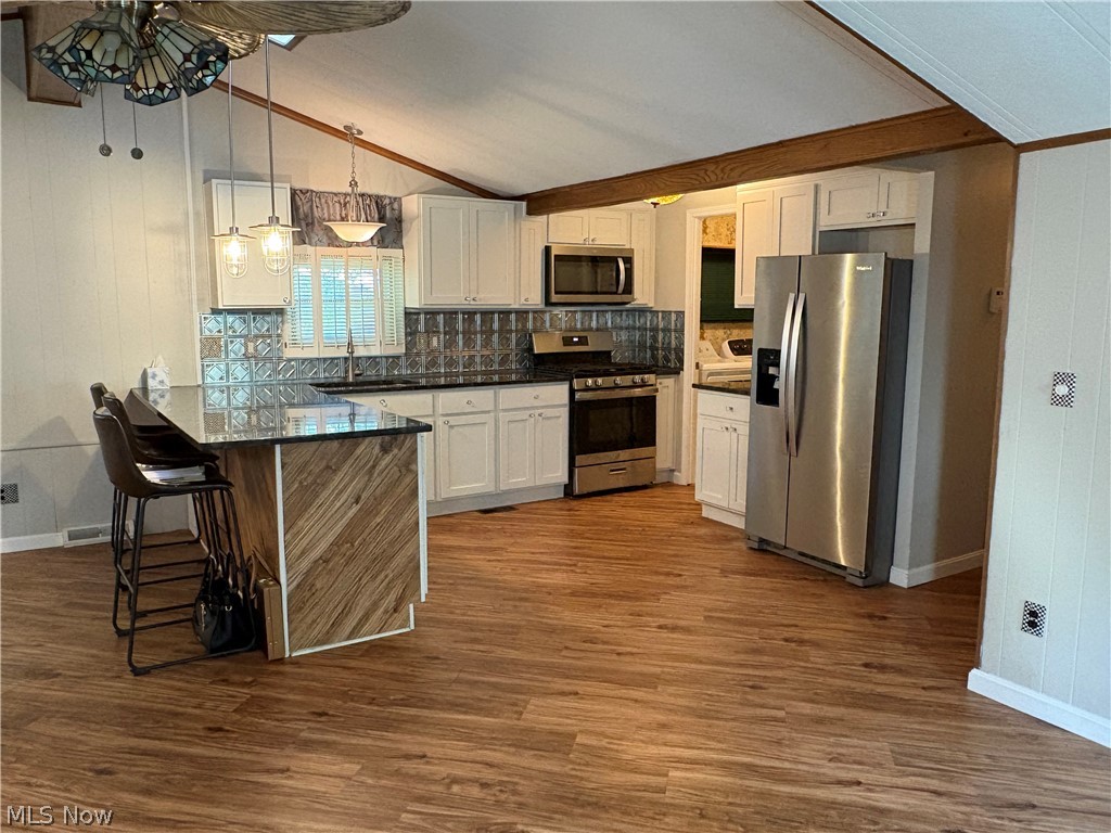 8701 Mayfield Road, Unit 148 Chesterland, OH 44026 - Photo 2 of 22 Modern kitchen (Remodeled 2 yrs ago) featuring granite countertops, white cabinetry, stainless steel appliances, and a patterned backsplash