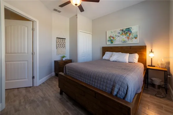 a bedroom with a bed a painting on the wall and a chandelier