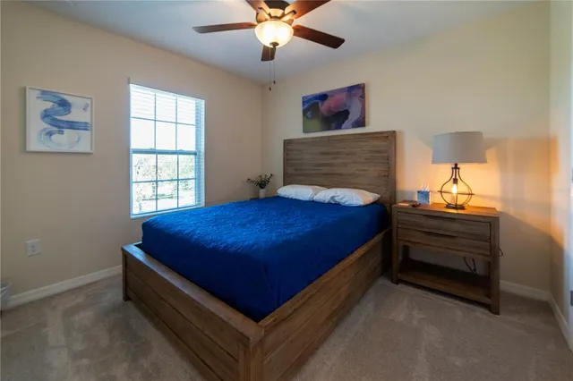 a bed room with a bed and a ceiling fan