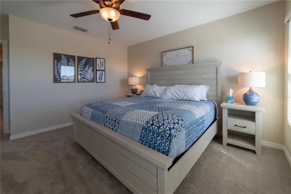 a bedroom with a bed chandelier and a window