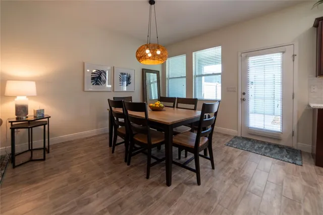 a dining room with furniture a chandelier and wooden floor