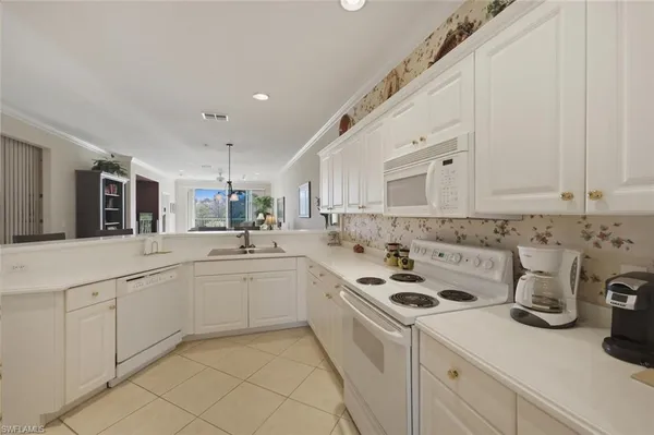 a kitchen with sink a stove and cabinets