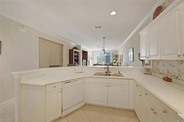 a kitchen with white cabinets appliances and sink