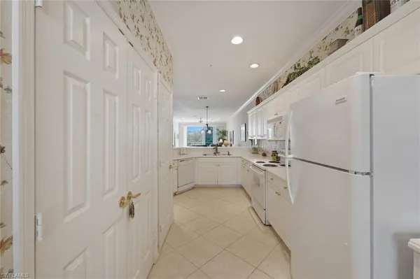 a kitchen with white cabinets and refrigerator