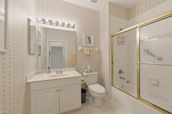 a bathroom with a toilet a sink a glass door a shower and a mirror