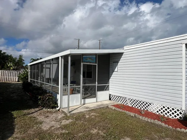a view of a house with a large window and wooden fence