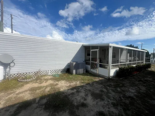 a view of house with backyard and sitting area