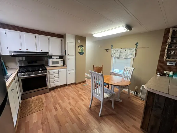 a kitchen with a table chairs a sink and dishwasher