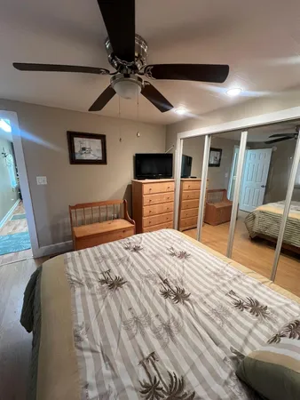 a bedroom with a bed and a flat tv screen on dresser