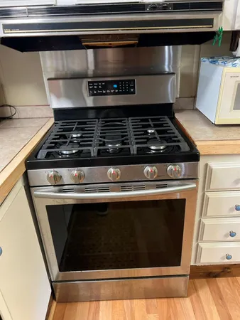a stove top oven sitting inside of a kitchen