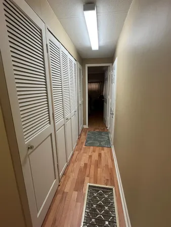 a view of a hallway with wooden floor and staircase