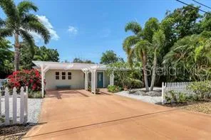 a view of a house with a yard and palm trees