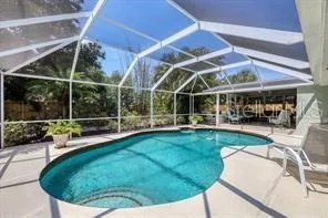 a view of a swimming pool with lawn chairs and a big yard