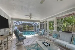 a living room with furniture a flat screen tv and a large window