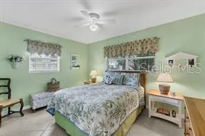 a bedroom with a bed a window and painting on the wall