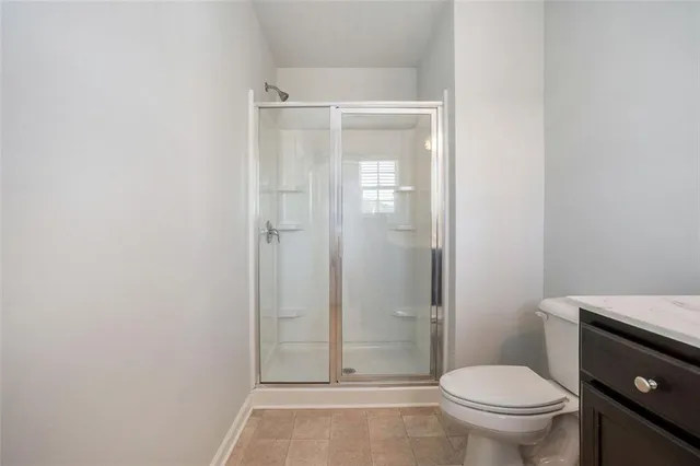 a bathroom with a granite countertop toilet and a shower