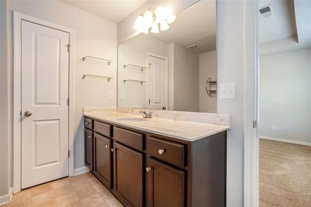 a bathroom with a granite countertop sink a mirror and a vanity
