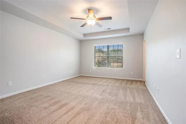 an empty room with windows and ceiling fan