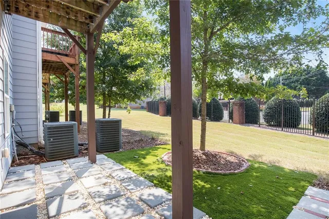 a view of a yard with plants and wooden fence