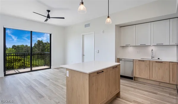 a kitchen with stainless steel appliances granite countertop a stove a sink dishwasher and a refrigerator with wooden floor