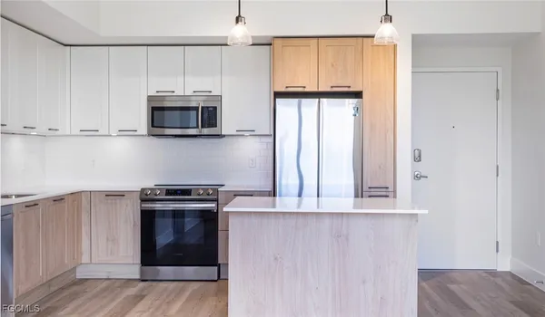 a kitchen with stainless steel appliances granite countertop a stove a microwave and a refrigerator