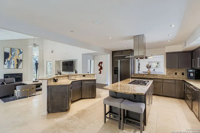 a large white kitchen with a stove a sink a dining table and chairs