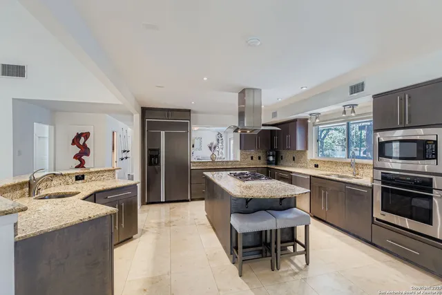 a large kitchen with cabinets table and chairs
