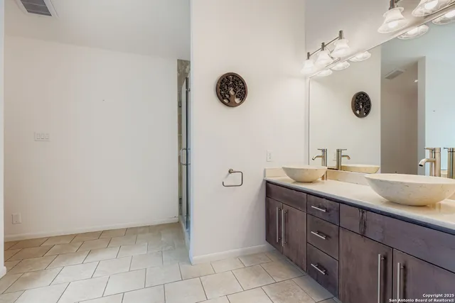 a spacious bathroom with a granite countertop sink a mirror and a shower