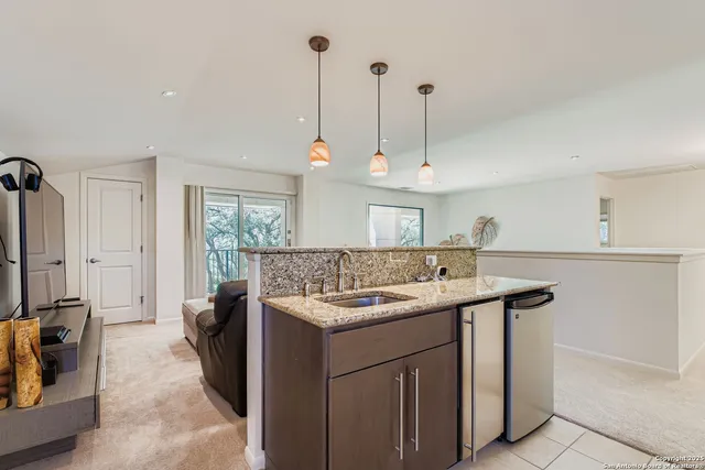 a kitchen with a sink a counter top space appliances and cabinets