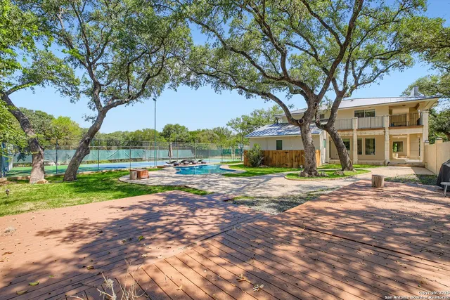 a view of a house with a big yard and large trees
