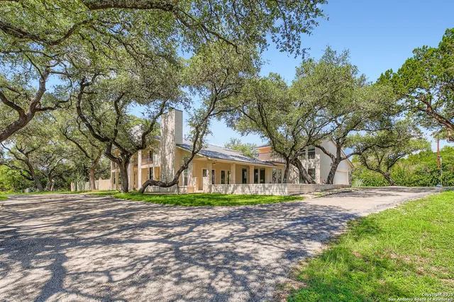 a front view of a house with a yard and trees