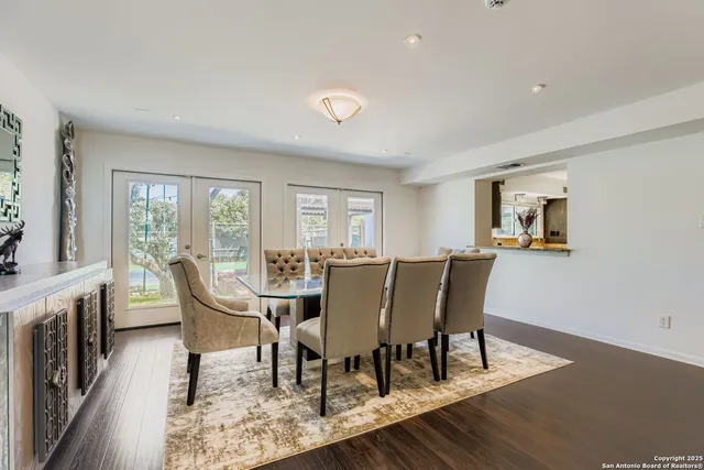 a view of a dining room with furniture a rug and wooden floor