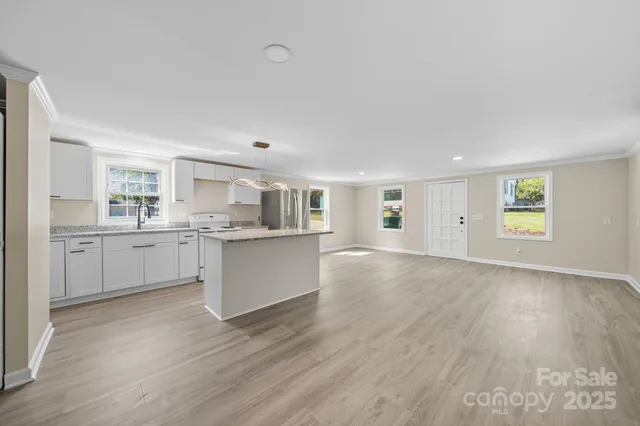 a view of a kitchen with wooden floor and windows