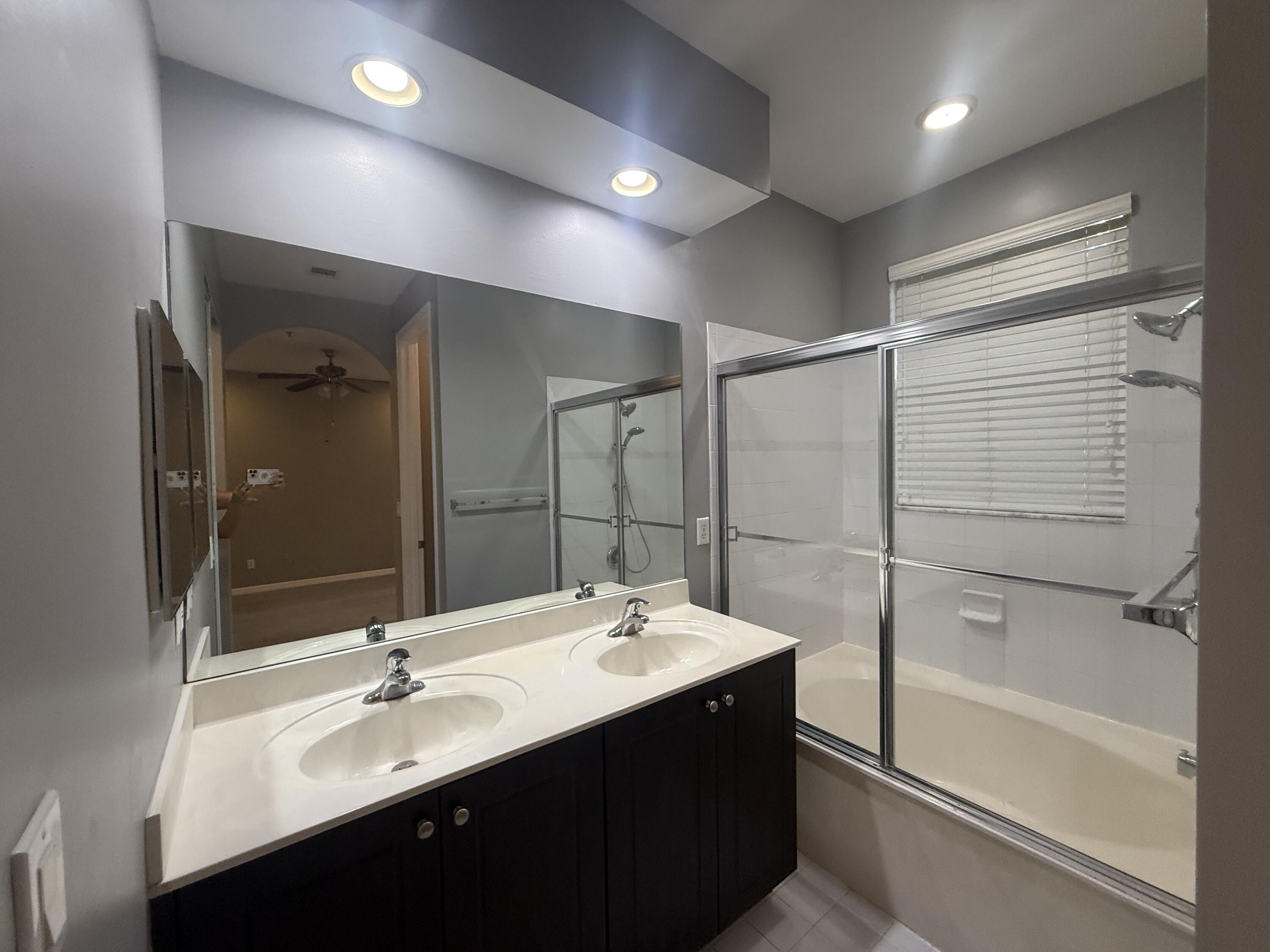 2851 Prospect Road, Unit 502 Tamarac, FL 33309 - Photo 6 of 17 a bathroom with a double vanity sink mirror and bathtub