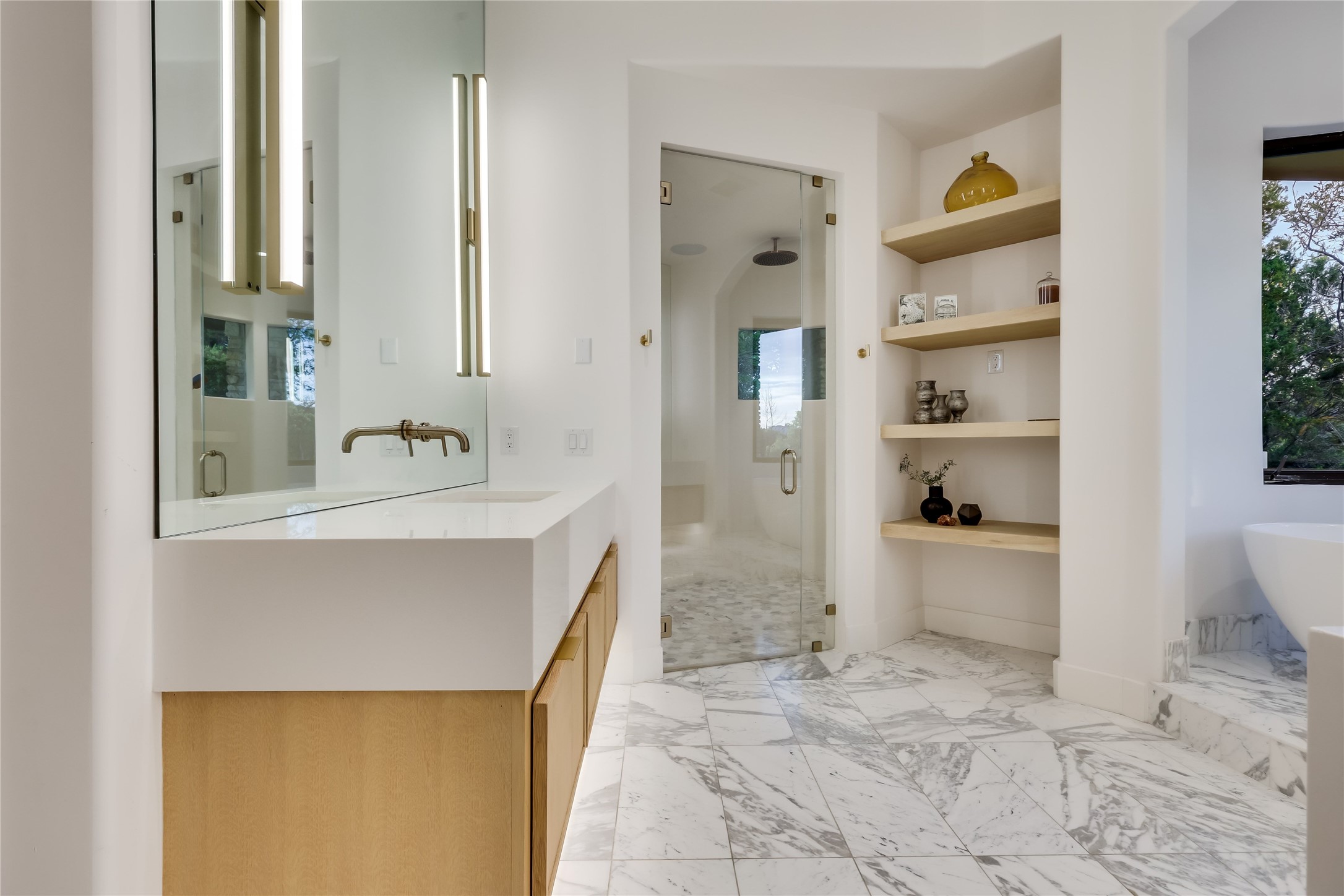 1016 Wild Basin Ledge Austin, TX 78746 - Photo 14 of 38 Primary bathroom featuring gold calcutta marble floors, a steam shower, a soaking tub, and vanities