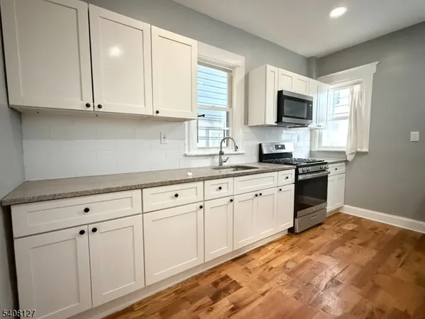 a kitchen with white cabinets and white appliances