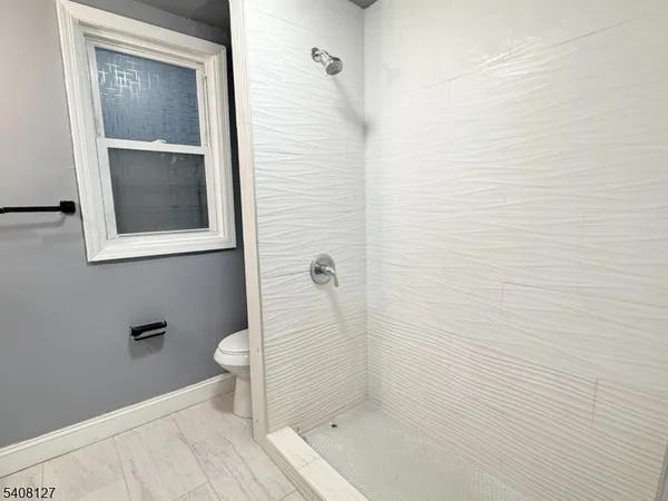 a bathroom with a granite countertop toilet and a shower