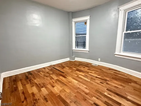 a view of a room with wooden floor and windows